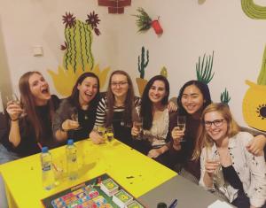 a group of women sitting around a table holding wine glasses at Travel&Joy backpackers in Prague