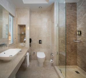 a bathroom with a toilet, sink, and bathtub at Titanic Business Kartal in Istanbul