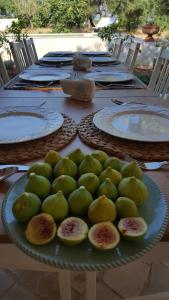 einen Teller mit grünem Obst auf dem Tisch in der Unterkunft The Proud Garden in Carovigno