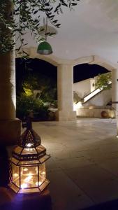 eine Laterne mit Licht in einem Innenhof in der Nacht in der Unterkunft The Proud Garden in Carovigno