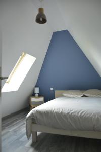 - une chambre avec un mur bleu et un lit dans l'établissement GITE "COTE JARDIN", à Vannecrocq