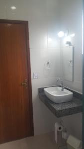 a bathroom with a sink and a mirror at Pousada Viva Mar in Saquarema