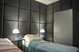 two beds in a room with black walls and lamps at Apartamenty Centrum- Kochanowskiego -dawniej two-bedroom Apartment in Zielona Góra