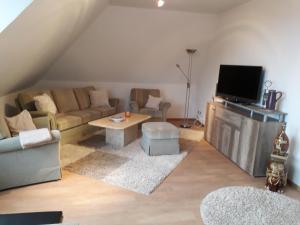 uma sala de estar com um sofá e uma televisão em Storchennest em Burg