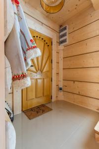 ムジャシフレにあるSichlański Zarymbek - Domek z Baliの木製のドアが備わるログキャビン内の客室です。