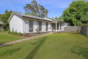 a white house with a fence and a yard at Acaronar in Bright