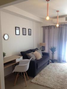 a living room with a blue couch and a desk at Neuquén Centro in Neuquén