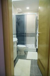 a bathroom with a toilet and a glass shower at Station in Osijek +60 photos