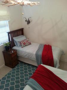 a bedroom with two beds and a bug on the ceiling at Harbour Views in Simonʼs Town