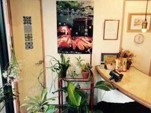 a room with potted plants on the wall at Kitatono Guest House in Matsue