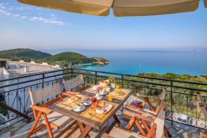 a table on a balcony with a view of the ocean at Arilla Beach Hotel in Perdika