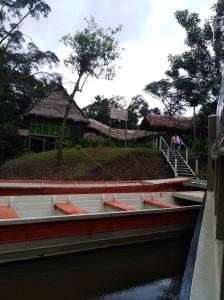 ein Boot im Wasser neben einem Gebäude in der Unterkunft Explorama Lodge in Francisco de Orellana