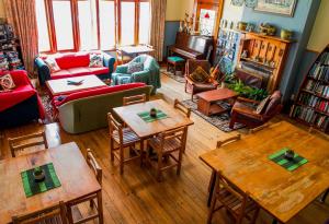 a living room filled with furniture and tables at Noah's Ark Backpackers in Greymouth