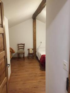 a bedroom with a bed and a chair in a room at El Pajar de Oncina Albergue Peregrinos in Oncina de la Valdoncina