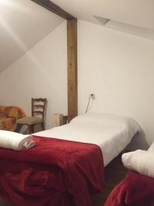 a bedroom with a bed with a red blanket and a chair at El Pajar de Oncina Albergue Peregrinos in Oncina de la Valdoncina