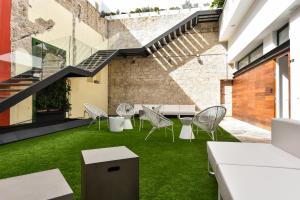 an internal courtyard with green grass and a table and chairs at OFF TRIANA in Las Palmas de Gran Canaria