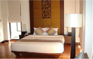 a bedroom with a large bed and a lamp at Chang Buri Resort & Spa in Ko Chang