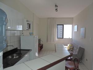 uma cozinha com um lavatório e um sofá num quarto em Flat Pina/Boa Viagem em Recife