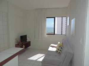 uma sala de estar com um sofá e uma janela em Flat Pina/Boa Viagem em Recife