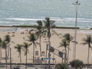 uma praia com palmeiras e o oceano em Flat Pina/Boa Viagem em Recife