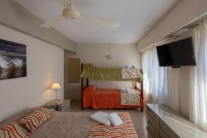 Un dormitorio con una cama y un televisor de pantalla plana. en Hotel Victoria, en Pinamar