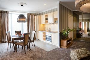 cocina y comedor con mesa y sillas en Ursula Royal Apartments, en Druskininkai