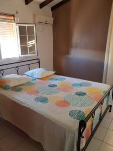 chez jojo في باي-ماؤو: غرفة نوم مع سرير وبطانية ملونة