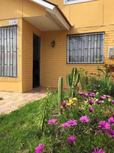 a house with a cactus and flowers in front of it at Casa Ana María in Coquimbo