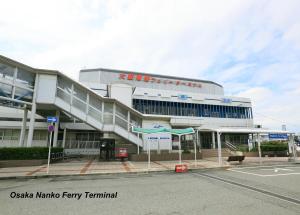 um grande edifício com um parque de estacionamento em frente em Meimon Taiyo Ferry 1st sailing from Osaka to Kitakyushu em Osaka