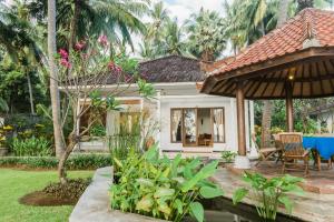 a house with a garden and a patio at Agung Bali Nirwana Villas and Spa in Tejakula