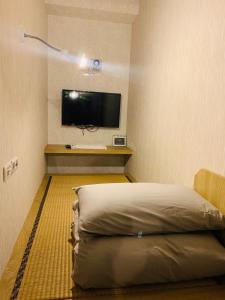 1 dormitorio con 1 cama y TV de pantalla plana en WORK INN TPE, en Taipéi
