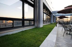 an outdoor patio with tables and chairs and grass at If Business Hotel in Changwon