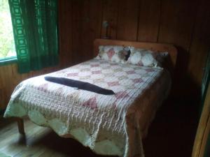 a bed with a blanket with two sticks on it at Las Cataratas Lodge in San Gerardo de Dota