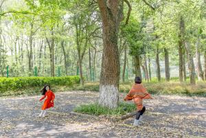 two young girls playing frisbee in a park at Millennium Resort Hangzhou in Hangzhou +78 photos