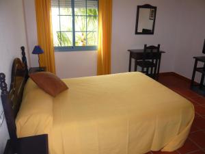 a bedroom with a bed and a table and a window at Hotel San Miguel in El Rompido