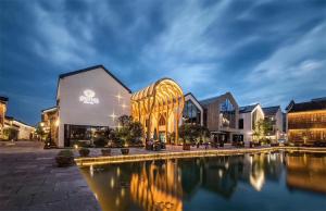 a building with a pool of water in front of it at EFC Oakmade Service Apartment in Hangzhou