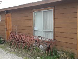 a red bench in front of a window on a house at Casa de Campo A Pasos De La Ciudad in Punta Arenas