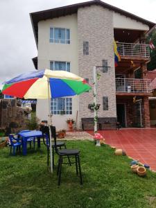 un paraguas colorido en el patio de una casa en Portal de la Cascada - Mongui, en Monguí