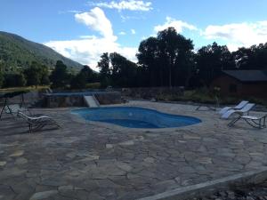 a swimming pool with chairs and a skate park at Hostal Santa Maria Huife in Pucón