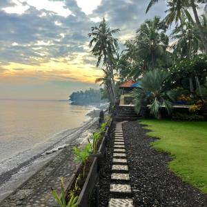 a pathway leading to a beach with a house at Agung Bali Nirwana Villas and Spa in Tejakula