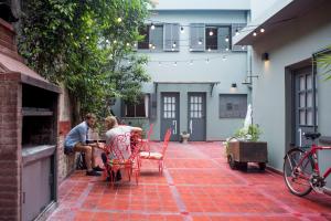 dos personas sentadas en una mesa en un patio en Puerto Limon Hostel en Buenos Aires