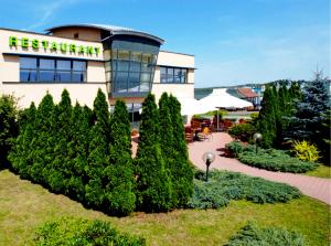 un bâtiment avec un restaurant avec des arbres devant lui dans l'établissement Campanile Katowice, à Katowice