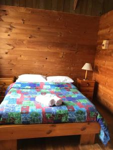 a bed with a quilt with a stuffed animal on it at Somerset Beachside Cabin And Caravan Park in Somerset
