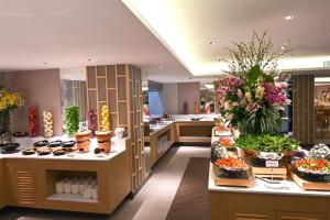 un ristorante con buffet di cibo e fiori di M Pattaya Hotel - SHA Extra Plus a Pattaya North