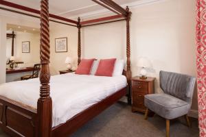 ein Schlafzimmer mit Himmelbett und Stuhl in der Unterkunft The Inveraray Inn, BW Signature Collection in Inveraray + 45 Fotos