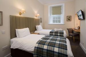 ein Hotelzimmer mit zwei Betten und einem Schreibtisch in der Unterkunft The Inveraray Inn, BW Signature Collection in Inveraray