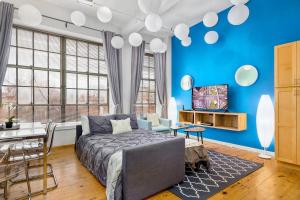a bedroom with blue walls and a bed and a table at Trifecta 2BR Free Parking Modern Superhost in Durham