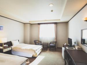 軽井沢町にある ホテル軽井沢エレガンスのベッド2台とテレビがあるホテルの部屋