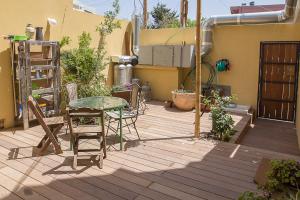 eine Terrasse mit einem Tisch und Stühlen auf einer Terrasse in der Unterkunft מקום בלב יפו Makom be Lev Jaffa in Tel Aviv