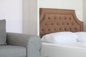 um quarto com uma cama, um sofá e uma almofada em Turquoise and Magenta Apartments em Sófia